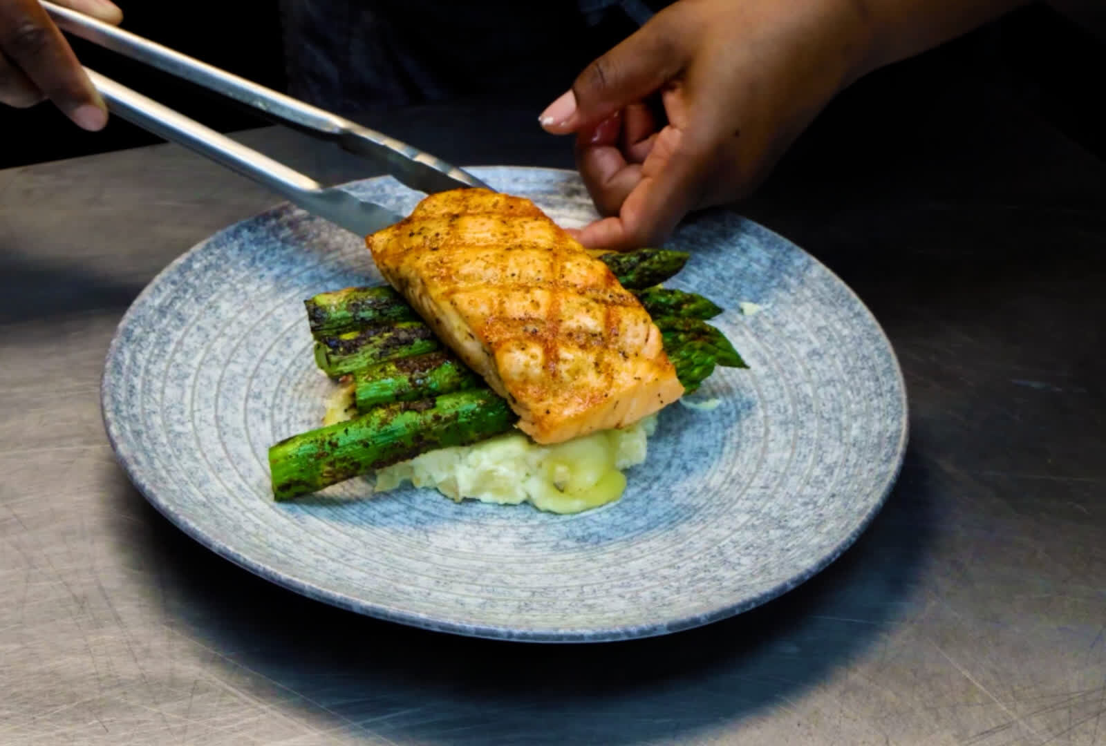 Chef plating grilled salmon with asparagus for Visit Orlando Magical Dining