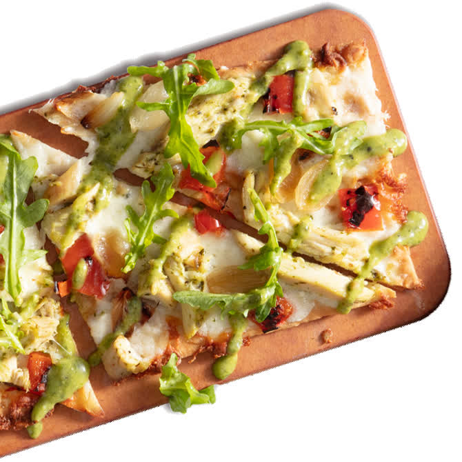 Seasons 52 chicken-pesto flatbread on a wooden board