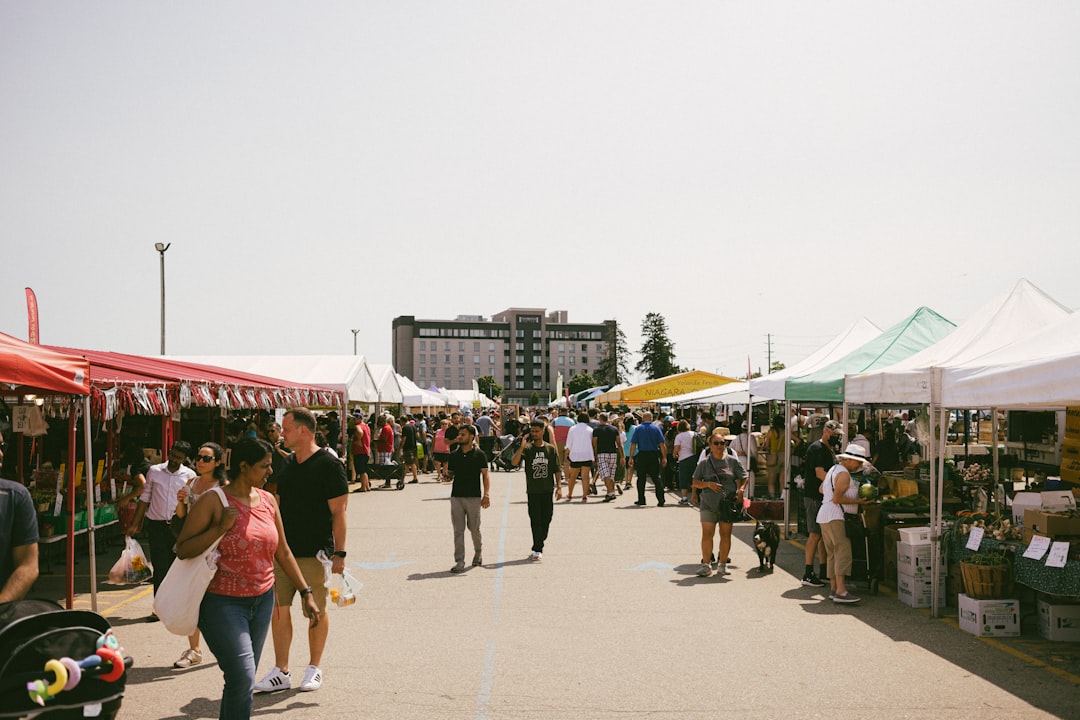 Crowds browsing an outdoor craft market with vendor stalls