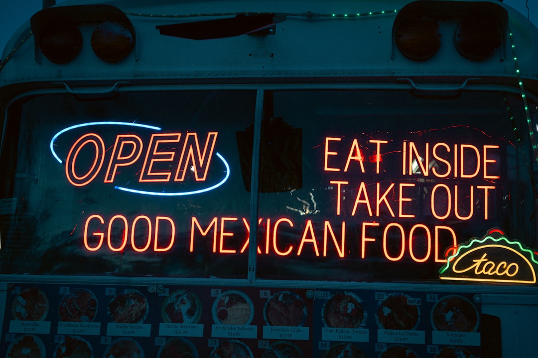 Neon sign outside a small taco window