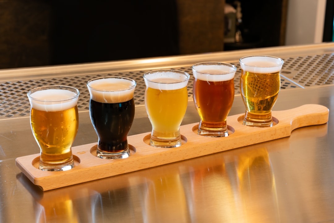 A flight of craft beer glasses on a wooden tray