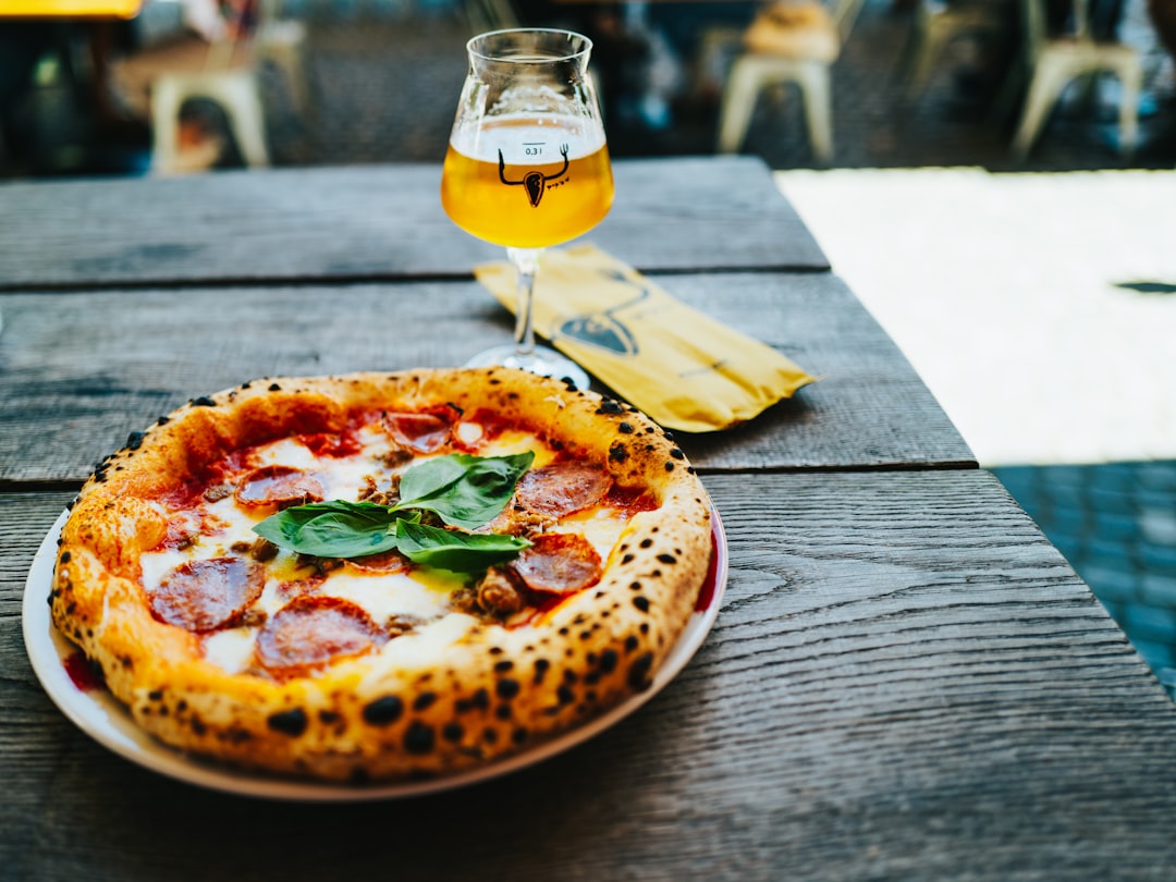 A wood-fired pizza fresh from the oven, served with beer